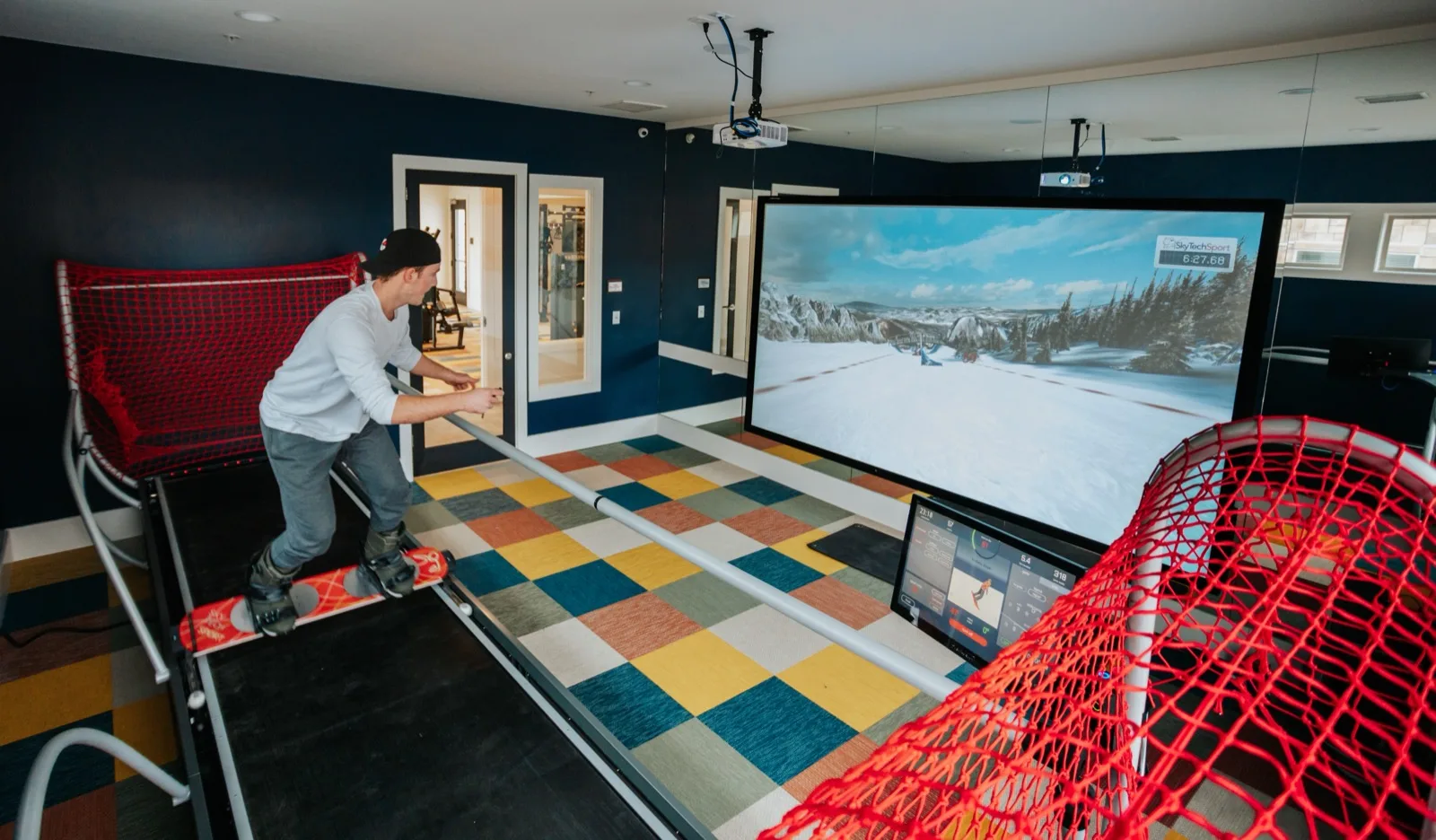 Snowboarding on a SkyTechSport simulator in a premium home installation — skiing and snowboarding both supported